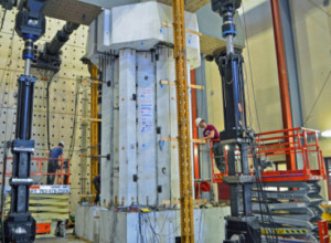 Iowa State doctoral student Robert Peggar, right, helps prepare a Hexcrete cross section for load tests at the University of Minnesota's MAST Laboratory.